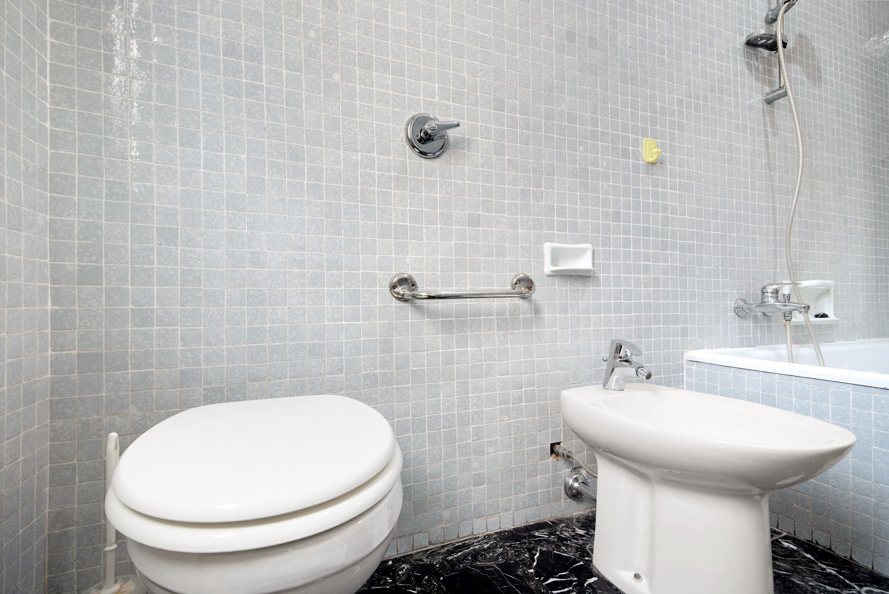A bathroom with a toilet, bidet, and bathtub.