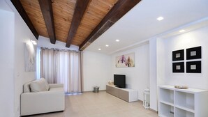 Un salon moderne avec un canapé, un téléviseur et des objets de décoration.
