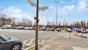 A parking lot with multiple cars and a street sign.