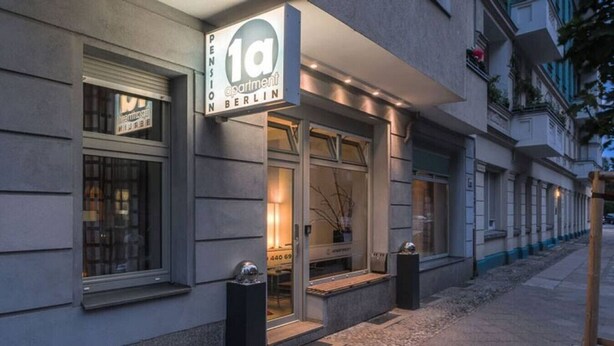 A building with a sign reading "1a Pension Berlin" indicating a pension apartment.