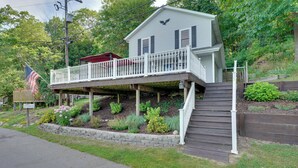 A two-story house with a balcony and a small deck. - Big Pine Island Lake Cottage w/ Boat Dock & Kayaks (Belding)