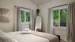A bedroom with a bed, two windows, a plant, and a whiteboard. - Lake-view! Hot Tub! Fire Pit. Grill. Game Room. King bed. (Luray)