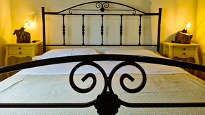 A bed with a metal frame and a headboard, flanked by two bedside tables with lamps. - Tobia's House  (Giuggianello)