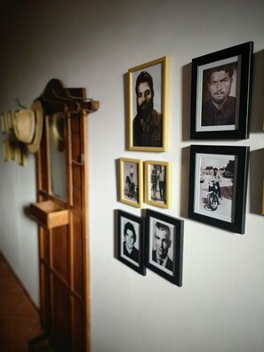 A wall with several framed photographs and a wooden guitar leaning against it. - Tobia's House  (Giuggianello)