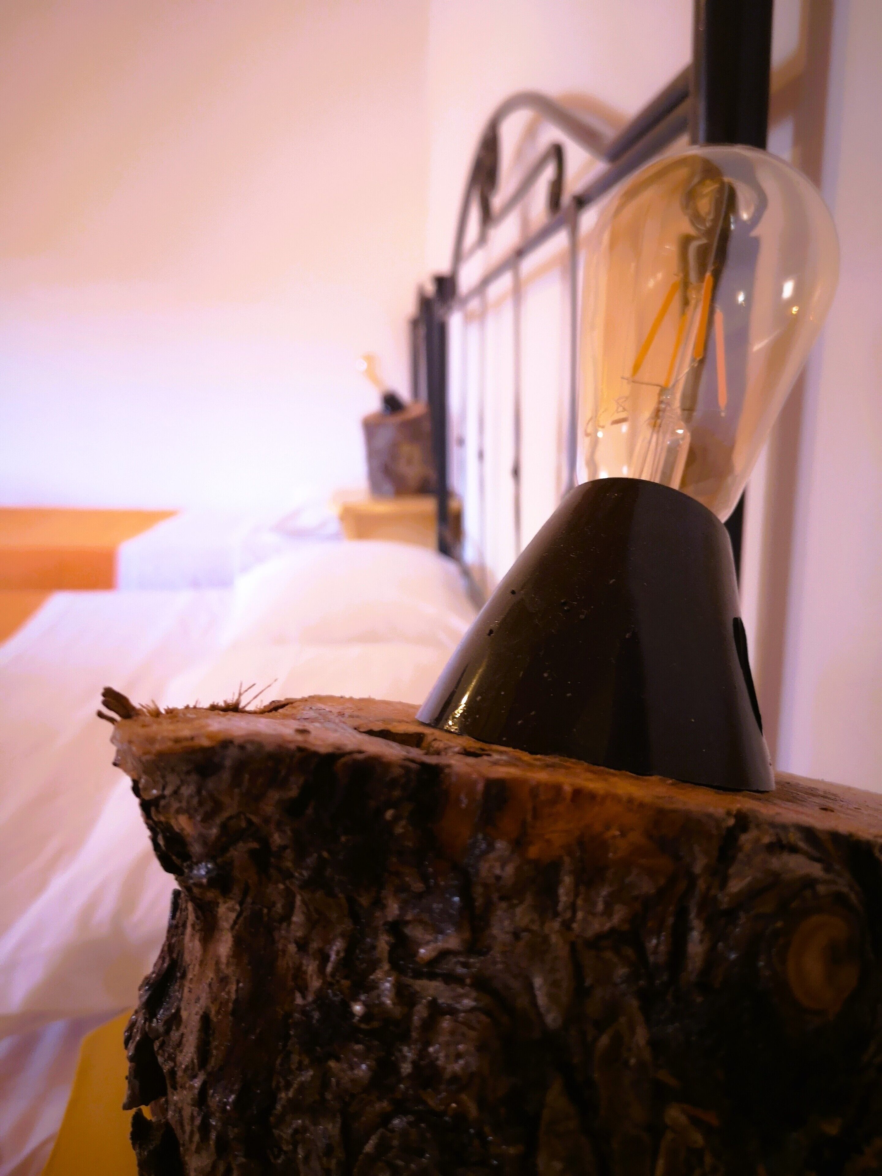 A lamp with a clear glass bulb on a wooden surface.