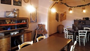 A rustic dining area with wooden furniture, a large table, and a wooden ceiling. - Tobia's House  (Giuggianello)