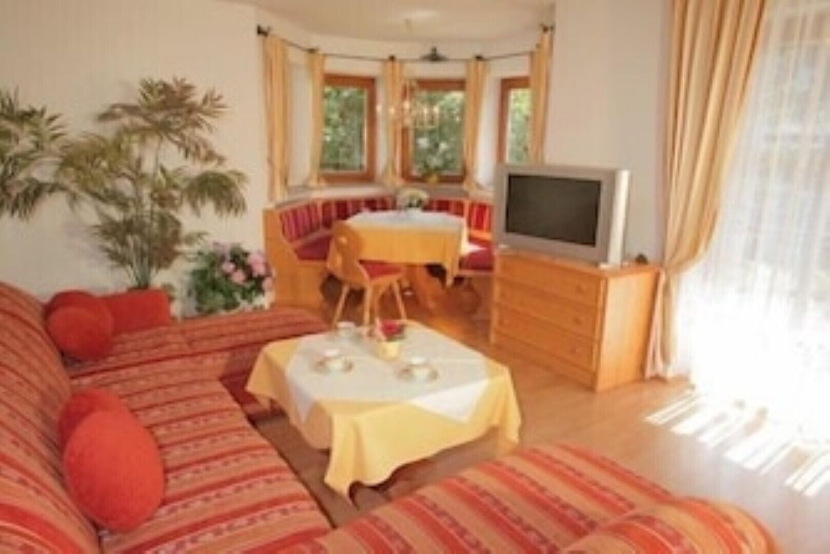 Una sala de estar con un sofá, una mesa de comedor y un televisor.