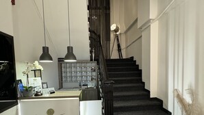 A hotel reception area with a staircase leading to an upper floor. - HOTEL ILISIA (Thessaloniki)