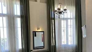 A hotel room with a bed, a desk, a chair, a sofa, and a small table. - HOTEL ILISIA (Thessaloniki)