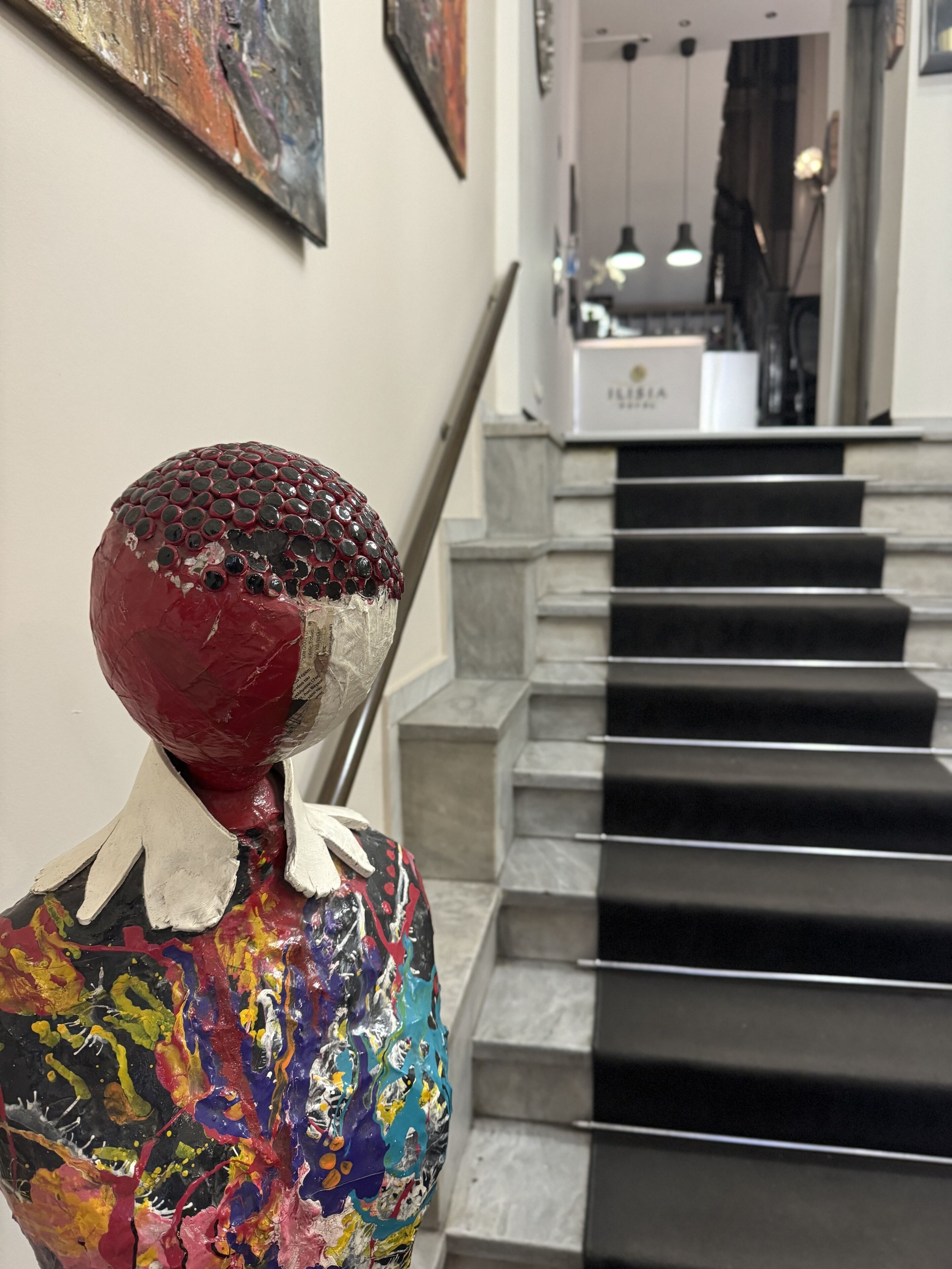 Eine Treppe mit einer roten und weißen Skulptur am Fuß.