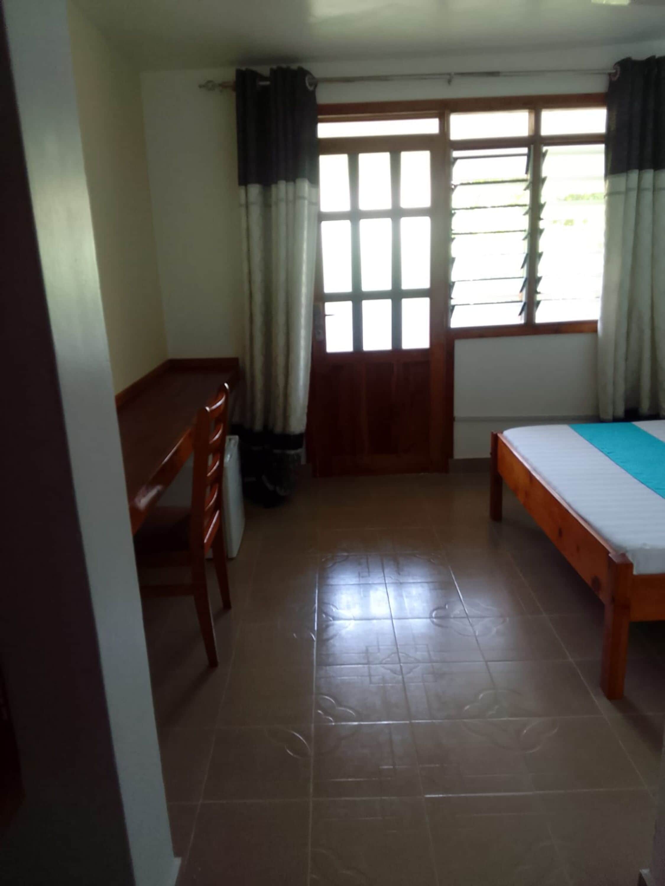 A room with a bed, a desk, and a chair.