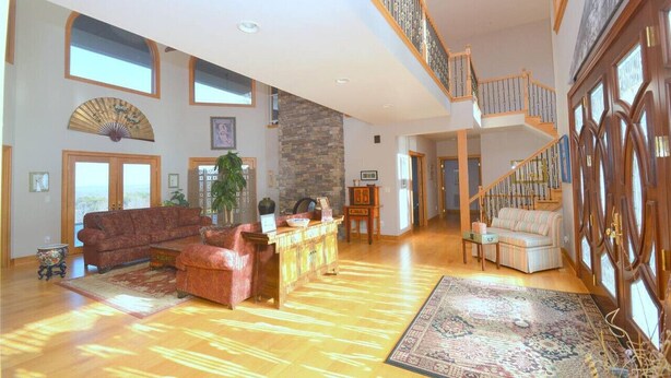 A spacious living area with a high ceiling, a staircase, and a view to the outside. - Redbud Keep - move theater, wifi, golf, view, recreation center access, grill (Hedgesville)