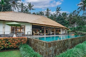 A resort with a pool, thatched-roof structure, and lush tropical surroundings. - Villa Themma Jungle (Payangan)