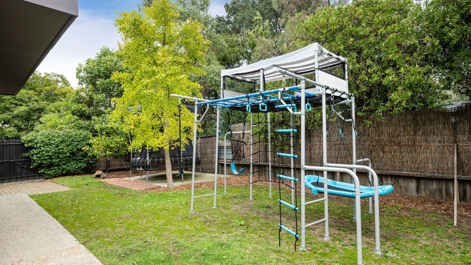 A playground with a climbing structure and swings.