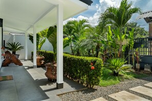 A covered outdoor area with potted plants, a pathway, and a well-maintained garden. - Uvita. Walk to beach. Pool. A/C. Fast internet (Uvita)