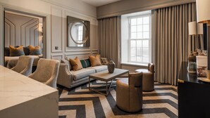 Una sala de estar moderna con un sofá, sillones, una mesa de centro y un televisor.
