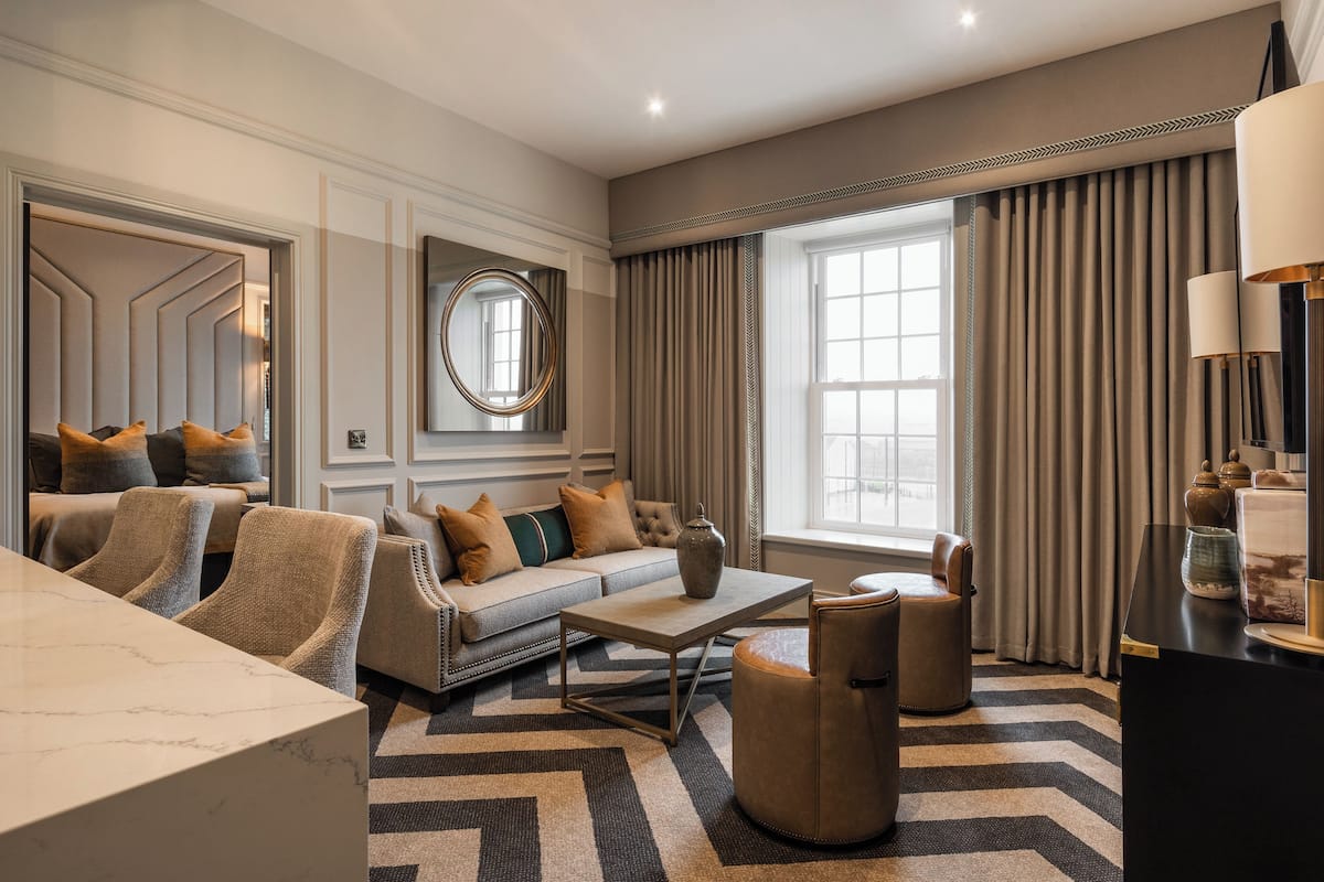 Un salon moderne comprenant un canapé, des fauteuils, une table basse et un téléviseur.