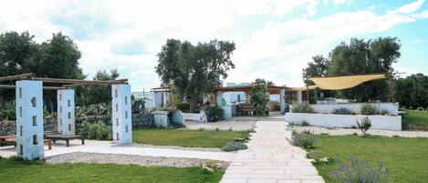 Un sendero de jardín que conduce a un pabellón con un pérgola.