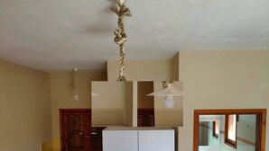 A compact kitchen with a refrigerator, microwave, and a small sink. - Georgias House Project First Floor (Skiathos)
