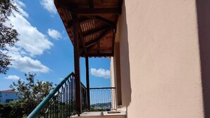 A staircase with a wooden pergola, metal railing, and beige walls leading to a building. - Georgias House Project First Floor (Skiathos)