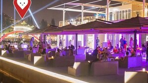 Un espacio al aire libre con bancos modernos y acolchados, y una sección cubierta.