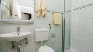 Un baño con lavamanos, inodoro y ducha.