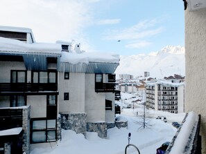 Um edifício coberto de neve com várias varandas e base de pedra.