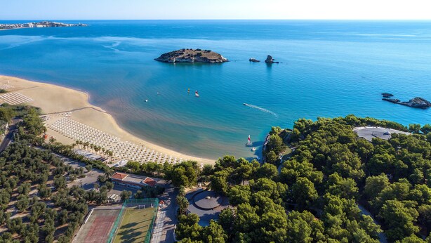 An aerial view of a coastal area with a beach, a small island, and a clear blue sea. - Gattarella Family Resort - Self-catering accommodations in the pinewood  (Vieste)