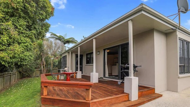 Une maison moderne dotée d’un patio couvert, d’une antenne parabolique et d’un garage.