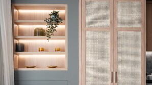 A modern room with a grey wall, wooden shelving with illuminated compartments, a wicker pouf, and a wooden wardrobe. - Acropolis Majestic view apartments (Athens)