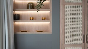 A modern room with a built-in shelf unit, a chair, and a woven pouf. - Acropolis Majestic view apartments (Athens)