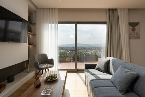 Appartamento panoramico, 1 camera da letto, terrazzo, vista città | Area soggiorno | Smart TV 50 pollici con canali via cavo, TV