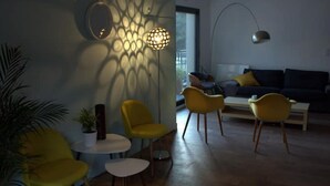 A modern living room with a sofa, yellow chairs, a coffee table, and a floor lamp. - 6-person air-conditioned gîte: terrace, garden, heated swimming pool 10 km from Lyon (Saint-Cyr-au-Mont-d'Or)