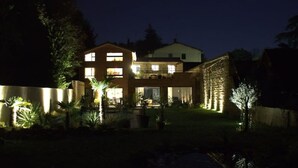 A two-story house with a well-lit front yard, a stone wall, and a small tree. - 6-person air-conditioned gîte: terrace, garden, heated swimming pool 10 km from Lyon (Saint-Cyr-au-Mont-d'Or)