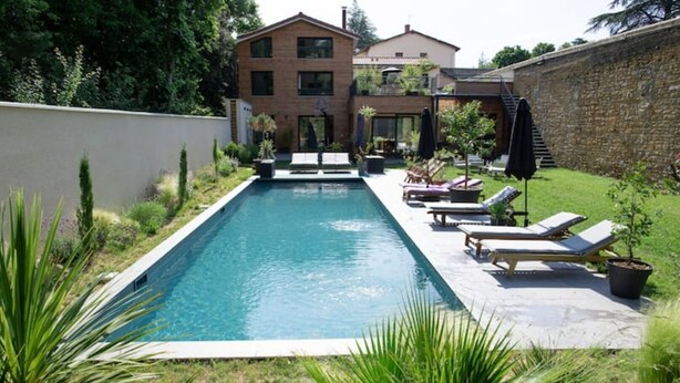 A rectangular swimming pool with lounge chairs and a small garden area. - 6-person air-conditioned gîte: terrace, garden, heated swimming pool 10 km from Lyon (Saint-Cyr-au-Mont-d'Or)
