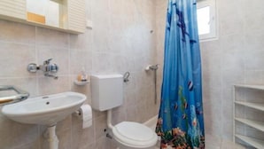 A bathroom with a sink, toilet, and shower curtain. - Apartments Boguvila - Two-bedroom Family Apartment With Terrace - (Supetar)