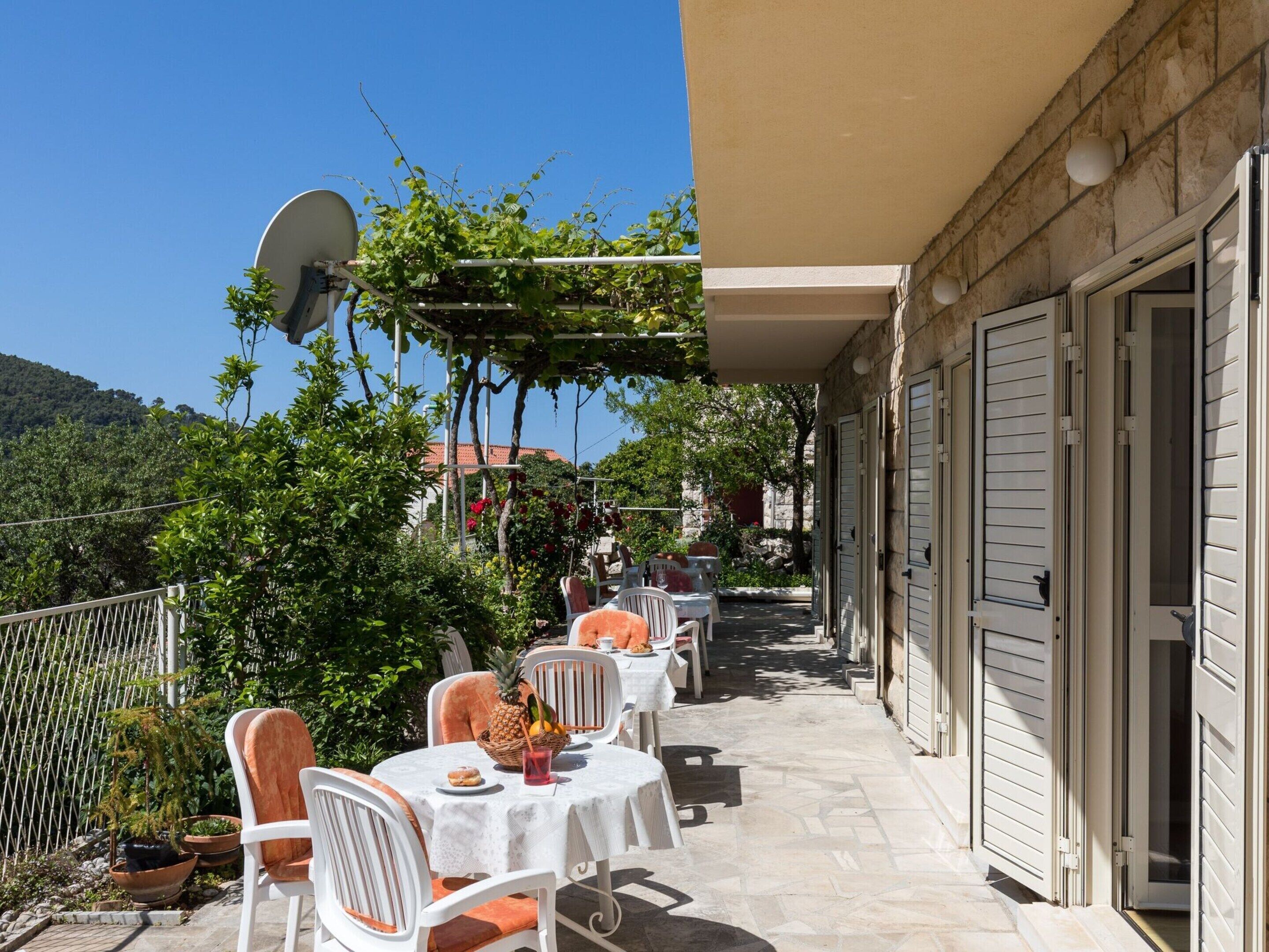 A terrace with outdoor seating, a satellite dish, and a view of the surrounding landscape.