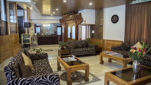 A lobby with patterned sofas, a reception desk, and a clock on the wall. - New Orchid Lords Inn Gangtok  (Gangtok)
