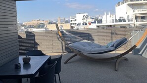 A rooftop terrace with a hammock, a table, and chairs. - Duplex Penthouse with Sauna & Acropolis View (Athens)