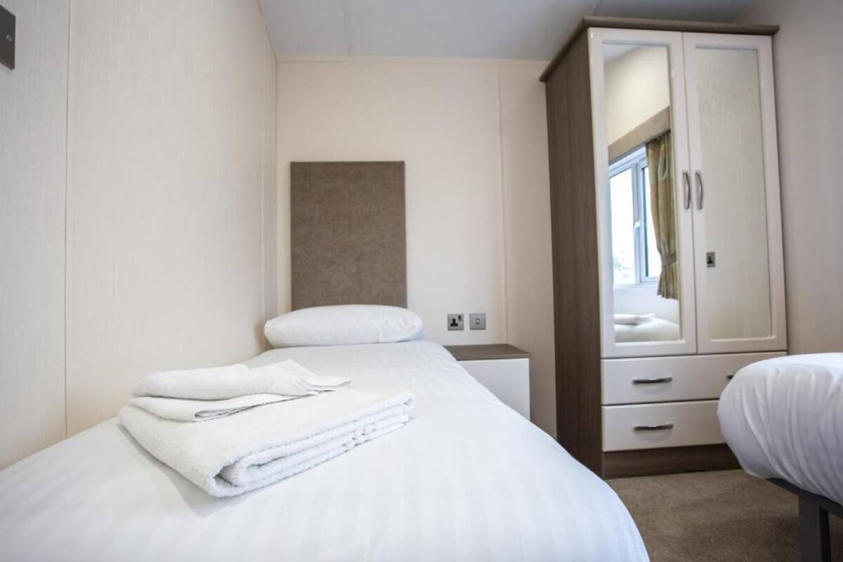 Une chambre d’hôtel comprenant un lit, une armoire, une table de chevet et un miroir.