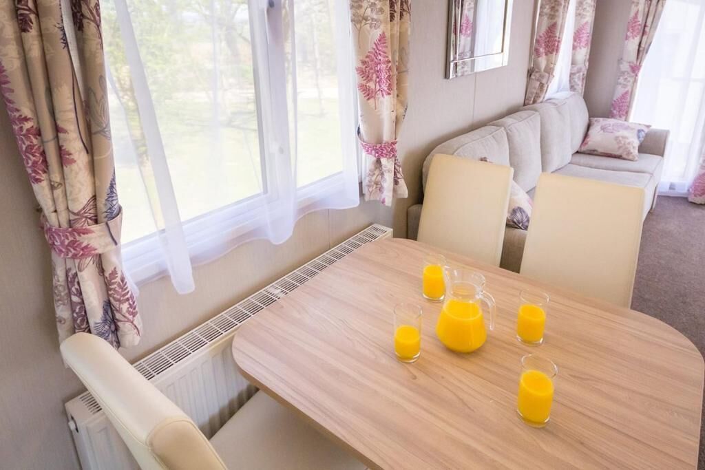 Une pièce chaleureuse avec une table en bois mise pour le petit-déjeuner, un canapé et un radiateur.