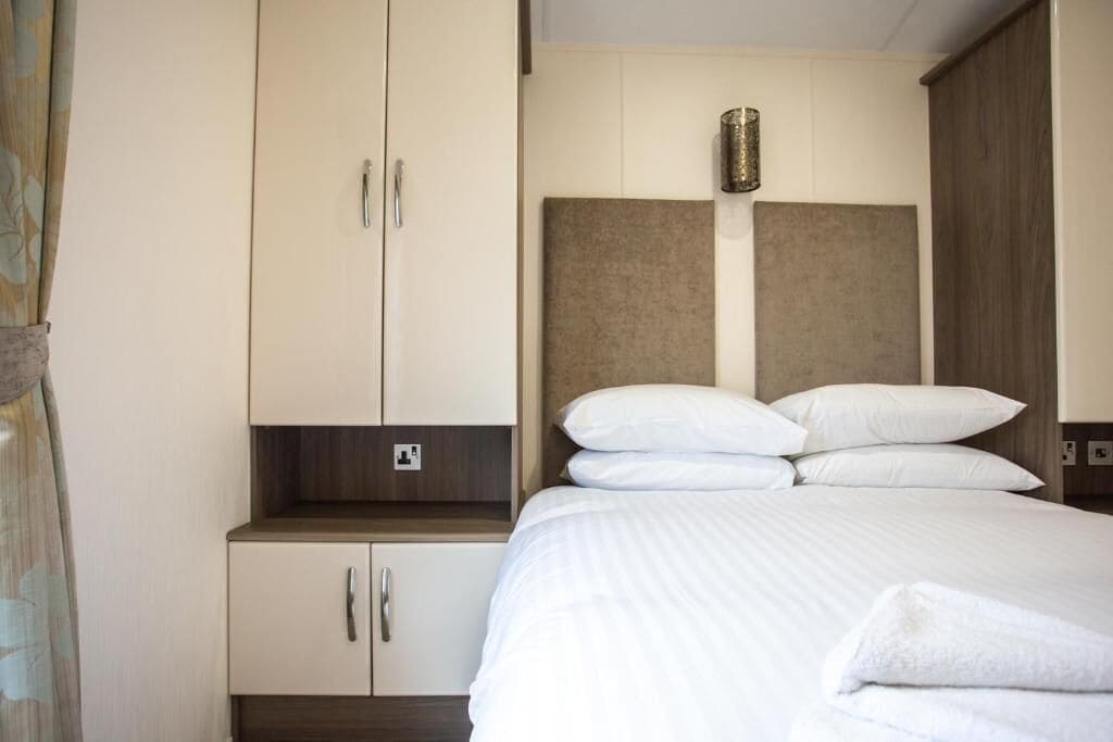 Een hotelkamer met een bed, een kledingkast en een nachtkastje.