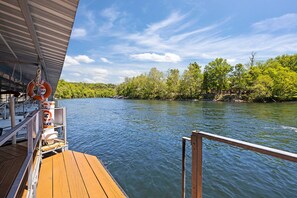 A wooden deck with a railing, a lifebuoy, and a sign indicating no swimming.
