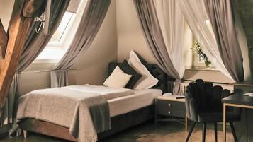 Un dormitorio con cama, mesita de noche, silla y cortinas.