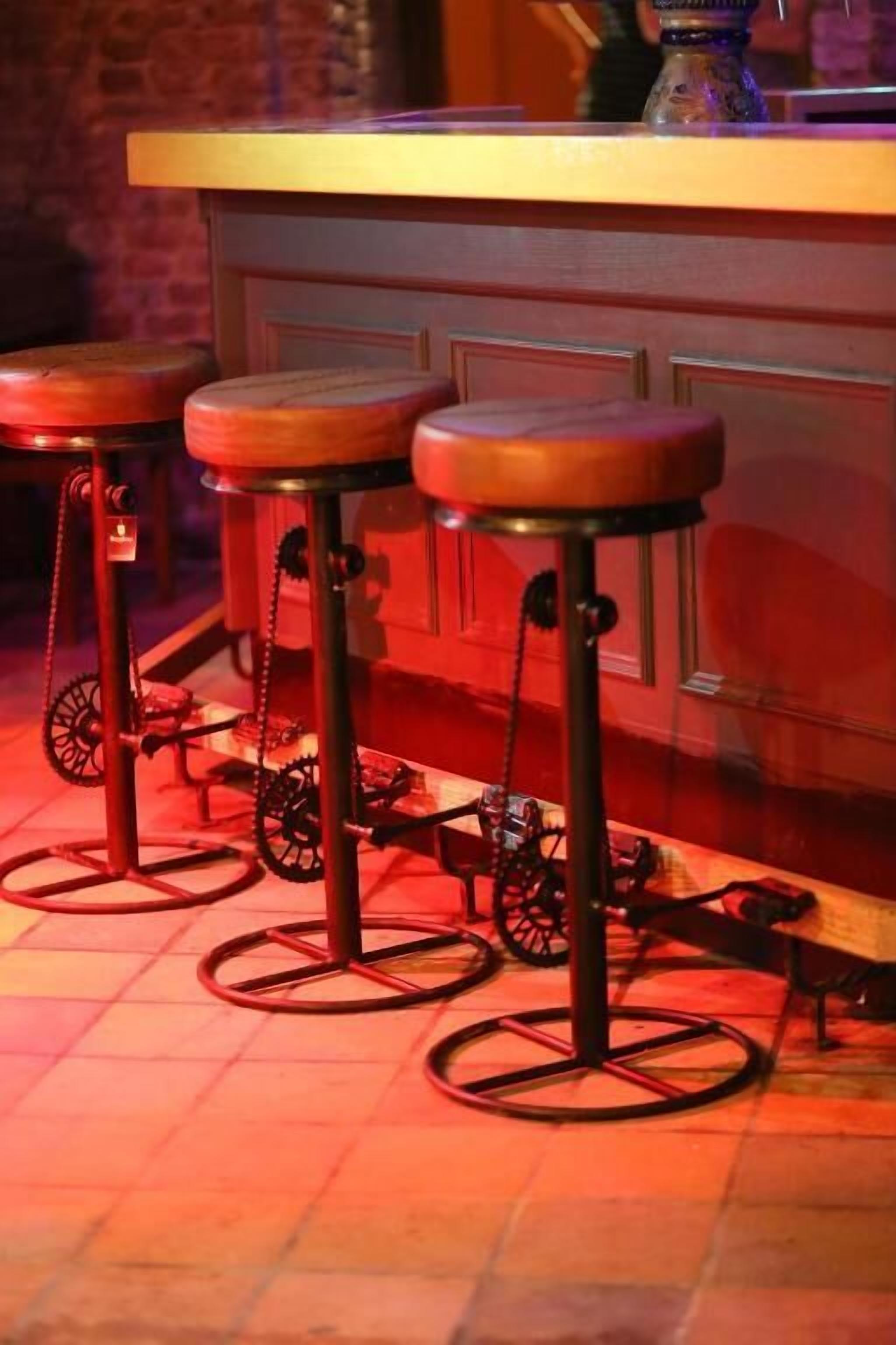 Una zona de bar con tres taburetes y una barra.