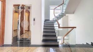 Un intérieur moderne avec un escalier en verre et un plancher poli.