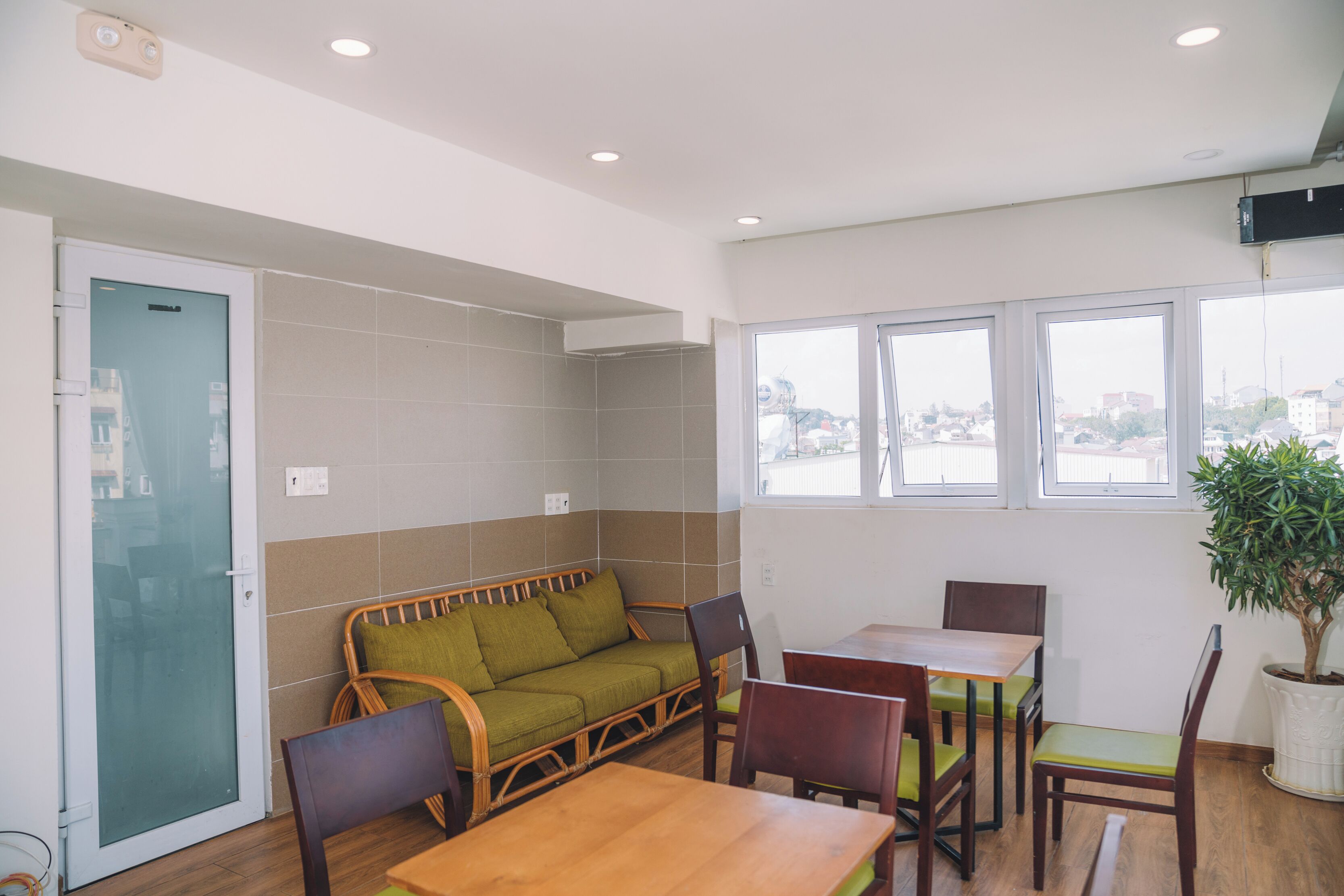 Un interior moderno con un sofá, una mesa de comedor, sillas y una planta en maceta.