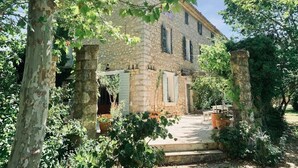 A stone building with a courtyard, surrounded by trees and potted plants. - La Bastide (Saint-Julien)