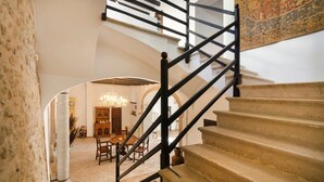 Una imponente escalera con barandilla negra que conduce a un piso superior.