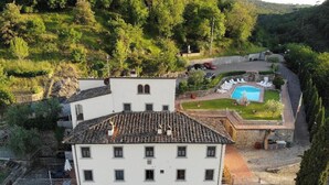 A white building with a tiled roof, a swimming pool, and a garden with lounge chairs. - 13 Palazzaccio Rock - Studio (Tavarnuzze)